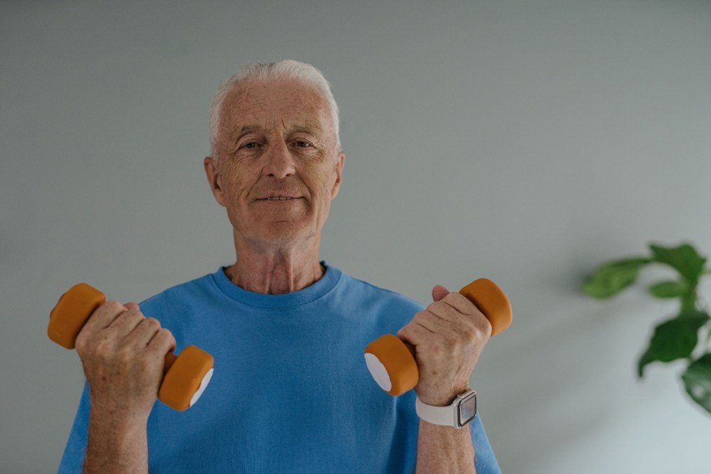 Physiotherapist assisting an older adult during a home-based mobility session